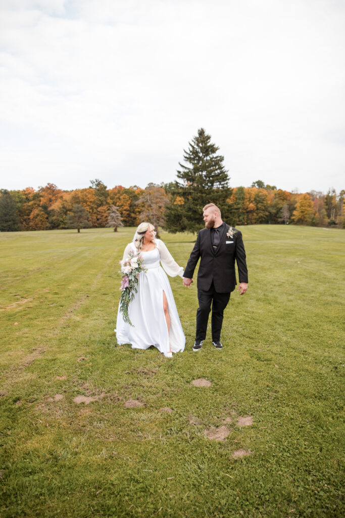 Bride and groom walk hand in hand on their wedding day in Northeast Ohio