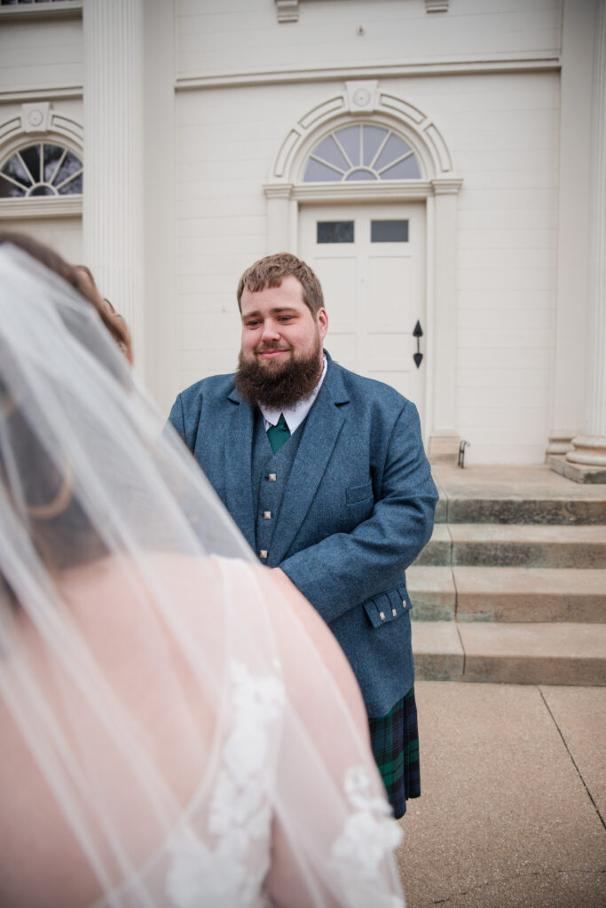 Groom wearing a traditional kilt during a winter wedding first look 