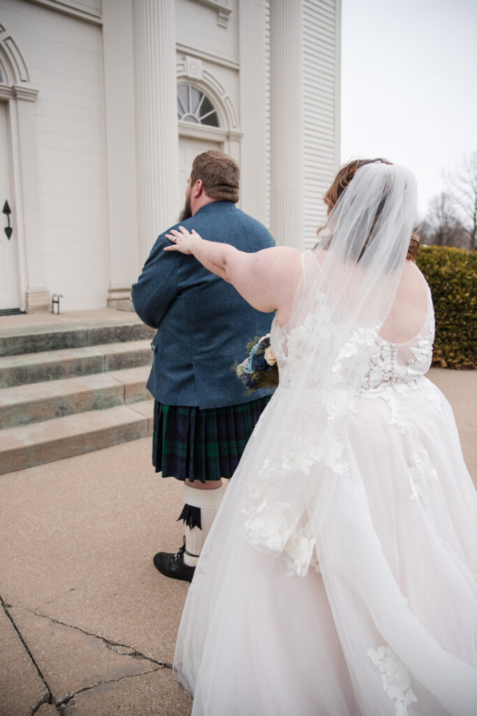 Groom wearing a traditional kilt during a winter wedding first look in Tallmadge Ohio