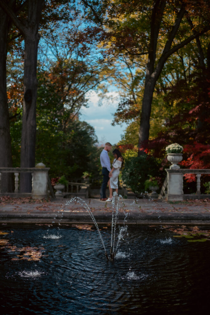 Engagement photo at Stan Hywet Hall and Gardens with couple standing by the fountain in Akron, Ohio