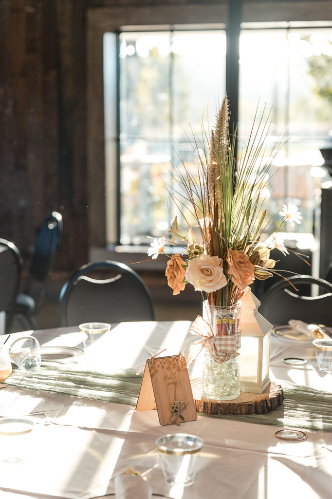Reception table centerpiece at Himelright Lodge with warm sunlight coming through the windows